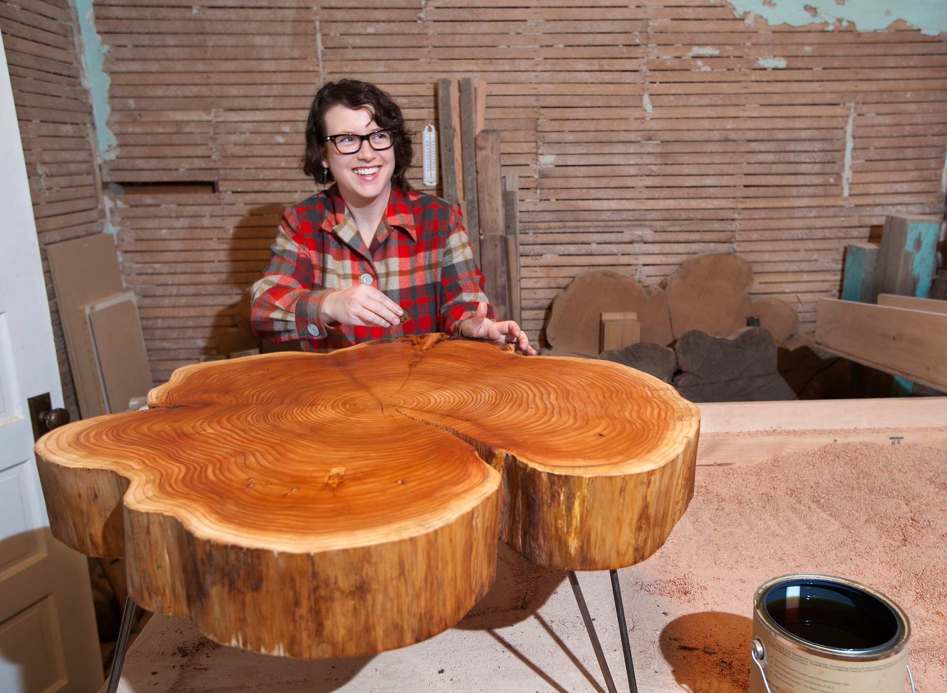 Adriene Wicks, co-owner of Birdloft, varnishes a Nimbus Cloud Coffee Table at her workshop
